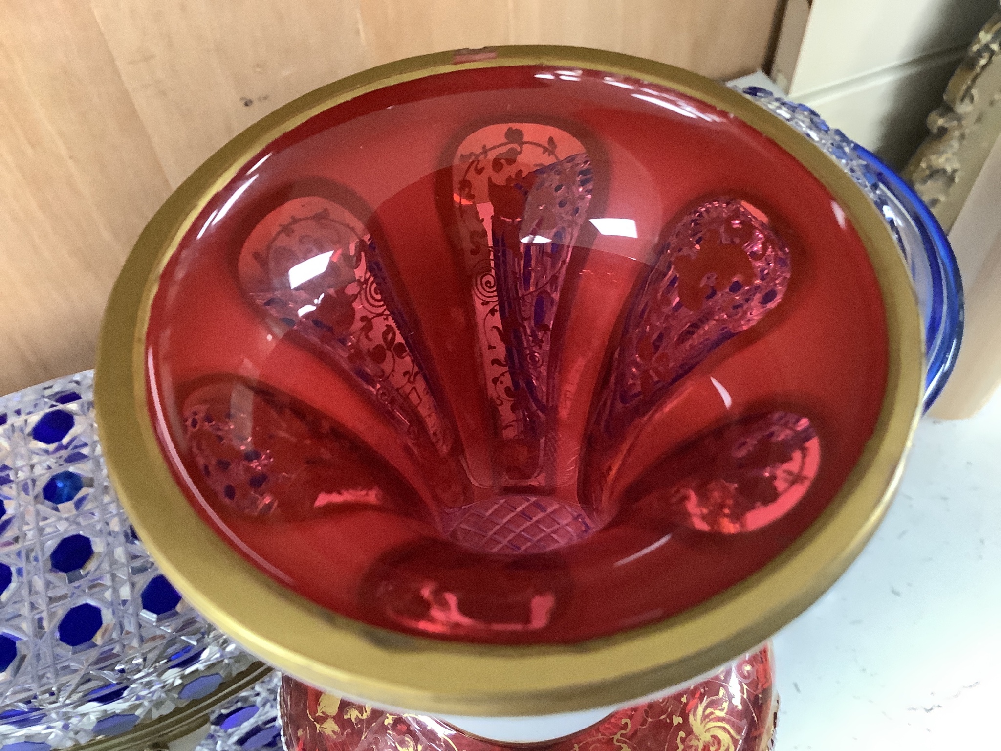 A 19th century Bohemian overlaid glass vase, 25.5cm, a similar gilded and enamelled beaker and two blue flashed hobnail glass biscuit boxes and covers